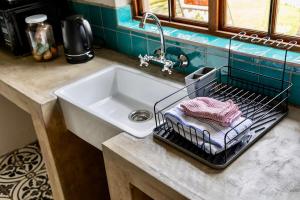 a kitchen counter with a sink and a basket with towels at Ebernburg Cottage in Nottingham Road