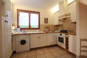 BreitenbachにあるLes Gites La Cerisaieのシンクと洗濯機付きのキッチン