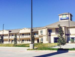 a large building with a sign in front of it at Days Inn & Suites by Wyndham Katy in Katy