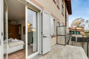 un balcón con una puerta que conduce a un dormitorio en Residence Due Laghi - Happy Rentals, en Ispra