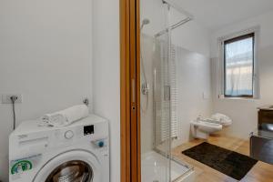 Un baño con lavadora y un inodoro. en Residence Due Laghi - Happy Rentals, en Ispra 20 fotos más