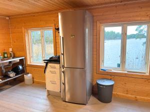 a kitchen with a stainless steel refrigerator in a cabin at Hus Upplångö in Figeholm