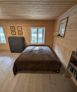 a bedroom with a large bed in a wooden room at Hus Upplångö in Figeholm +33 photos