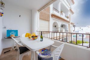 - Balcón blanco con mesa blanca y sillas en Palm Beach Apartment, en La Herradura