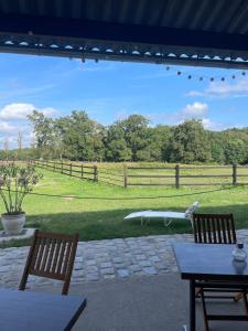 patio con 2 sedie e vista su un campo di Gîte duo à la campagne Les Grandes Maisons SPA HAMMAM accès avec sup a Lorris Altre 28 foto