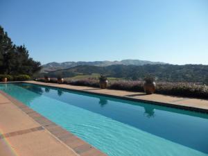 una grande piscina blu con montagne sullo sfondo di The Casitas of Arroyo Grande ad Arroyo Grande