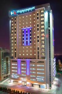 a large building with blue lights on top of it at Holiday Bahrain Hotel in Manama