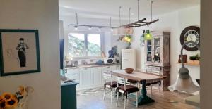 una cucina con tavolo, sedie e frigorifero di House with air conditioning and outdoor private area in Rosignano Marittimo a Rosignano Marittimo Altre 20 foto
