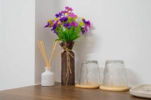 Hai Homestay And Space في كان ثو: مزهرية بها زهور أرجوانية على رف +26 صورة