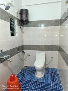 a bathroom with a toilet and a sink at whirlwind food court and resort in Numāligarh