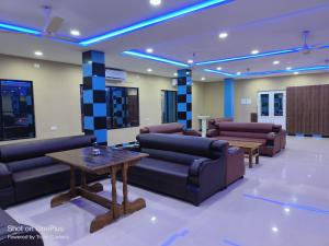 a waiting room with couches and a table at whirlwind food court and resort in Numāligarh