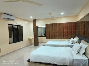 a hotel room with two beds and a couch at whirlwind food court and resort in Numāligarh