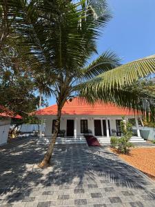 a palm tree in front of a building at Marari Arattukulam Villa in Mararikulam +53 photos