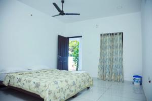 a bedroom with a bed and a ceiling fan at Marari Arattukulam Villa in Mararikulam +53 photos