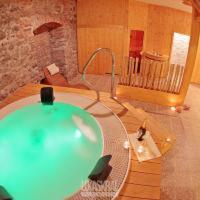 a bathroom with a bath tub with a glass table at Hotel Horní Dvůr in Nové Město na Moravě