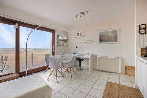 a living room with a table and a view of the ocean at Atlantis 0102 in Sint-Idesbald