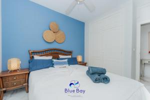 un dormitorio azul con una cama con un cartel azul en ella en Palm Beach Apartment, en La Herradura