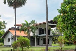 a house with palm trees in front of it at Villa17 Kalpitiya for Kitesurfing in Puttalam