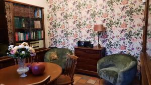 a room with two chairs and a table with flowers on the wall at 't Kabinet in Blankenberge