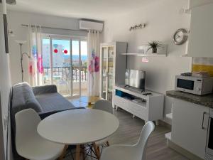 salon z białym stołem i kuchnią w obiekcie Playa Torrecilla, a un paso del centro peatonal! w mieście Nerja