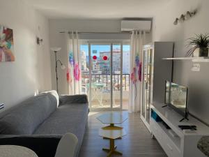 salon z kanapą i telewizorem w obiekcie Playa Torrecilla, a un paso del centro peatonal! w mieście Nerja