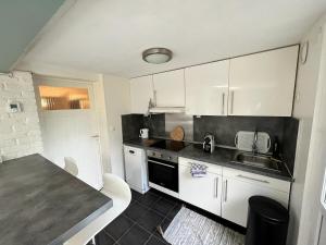 a kitchen with white cabinets and a counter top at Rez-de-jardin proche Lille in Marcq-en-Baroeul