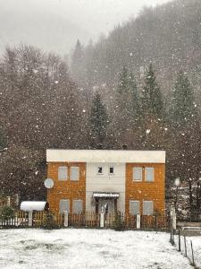 a building in the snow with snow falling on it at Villa Gryka in Peje