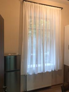 ein Fenster mit weißen Vorhängen in einem Zimmer in der Unterkunft Pikrisgora-luxury in Tbilisi City