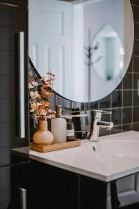 Un mostrador de baño con un lavabo y un espejo. en Sjøgata Apartment, en Kabelvåg