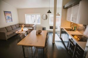Una cocina y una sala de estar con una mesa y un sofá. en Sjøgata Apartment, en Kabelvåg 2 fotos más