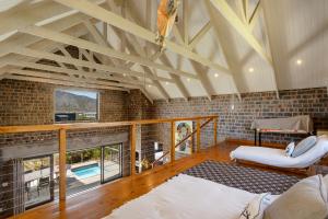 a living room with a vaulted ceilings and a fireplace at Secure, luxurious with lovely views in Pringle Bay