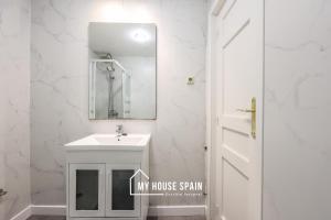 ein weißes Badezimmer mit Waschbecken und Spiegel in der Unterkunft MyHouseSpain - Great apartment 6 PAX MADRID CITY CENTER in Madrid + 14 Fotos