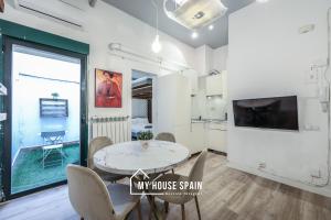 ein Esszimmer mit Tisch und Stühlen und einem Fernseher in der Unterkunft MyHouseSpain - Great apartment 6 PAX MADRID CITY CENTER in Madrid