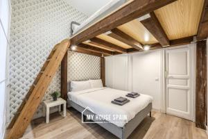 ein Bett in einem kleinen Zimmer mit einer Treppe in der Unterkunft MyHouseSpain - Great apartment 6 PAX MADRID CITY CENTER in Madrid