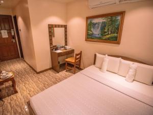 ein Hotelzimmer mit Bett und Schreibtisch in der Unterkunft Hotel La Maria in Guiuan