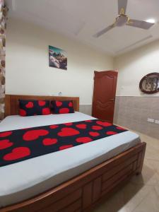 a bedroom with a large bed with red pillows at Saceaas homes in Accra