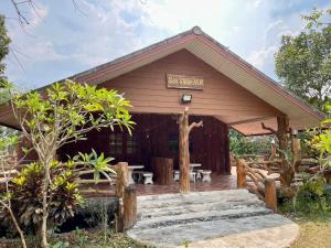 a resort with a wooden building with a porch at ไร่ภูตะวัน in Ban Muang Ton Mamuang