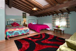 a bedroom with two beds and a rug at Antigua Posada, Valle del Jerte in Tornavacas