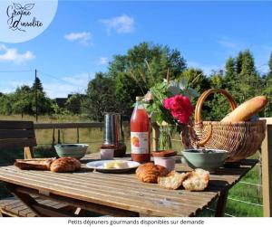 a picnic table with bread and a basket of flowers at Graine d'insolite in Imbleville