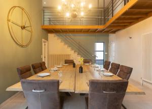 a dining room with a large wooden table and chairs at Vakantiehuis Piantho in Overpelt