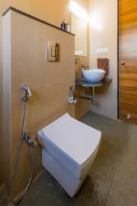 a bathroom with a toilet and a sink at SaffronStays Blue Jasmine in Nashik