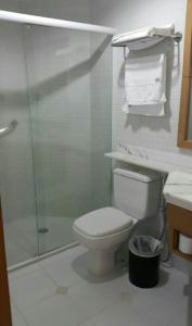 a bathroom with a toilet and a glass shower at Flat Araucaria Plaza in Ribeirão Preto