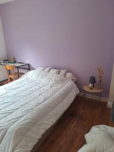 a bedroom with a large white bed and a table at 140 m2 , 3 lits 2 place et 1 canapé convertible 2 place in Lanvaudan