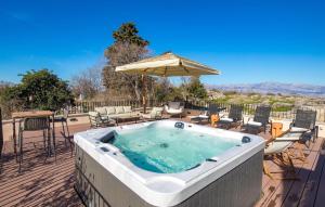 a hot tub on a deck with chairs and an umbrella at Cozy Home In Skrip With Wifi in Škrip