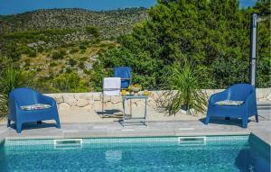 two chairs and a table next to a swimming pool at 1 Bedroom Lovely Home In Bobovisca in Bobovišća