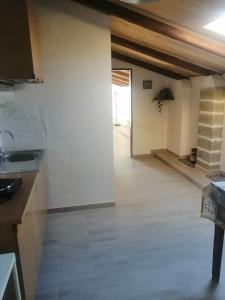 eine Küche mit weißen Wänden und Holzboden in der Unterkunft B&B Babbaro - camera con bagno privato in Castelcivita