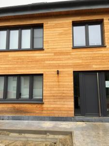 TieltにあるKrie1の黒い窓のある木造の家