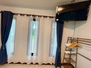 a curtain in a room with a window at Baan rabianglay 2 in Ban Hin Sam Kon