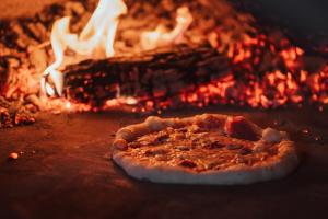 Una pizza è seduta davanti al fuoco di Katarino SPA Hotel a Bansko