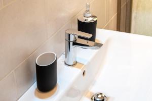 a sink with a faucet and two cups on it at Bilocale Incantevole in Casalecchio di Reno +17 photos